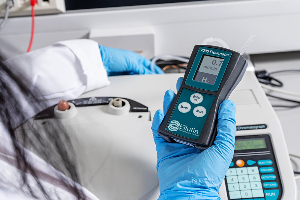 Person holding a flowmeter with Ellutia branding in a medical setting.